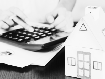 Black and white image of house and calculator with files