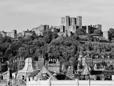 Black and white image of kent with houses and castle on a hill